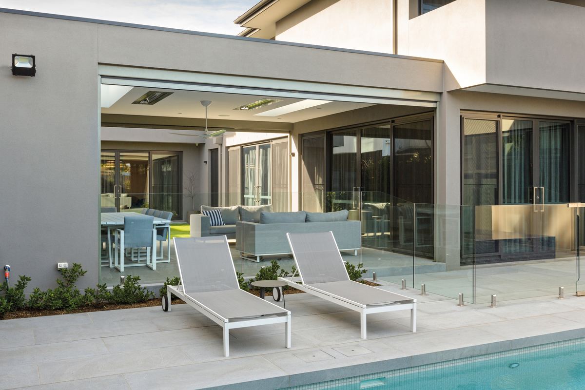 Poolside alfresco on a CQ home with the Zipscreen rolled right up, the lounge and dining setting open to the pool